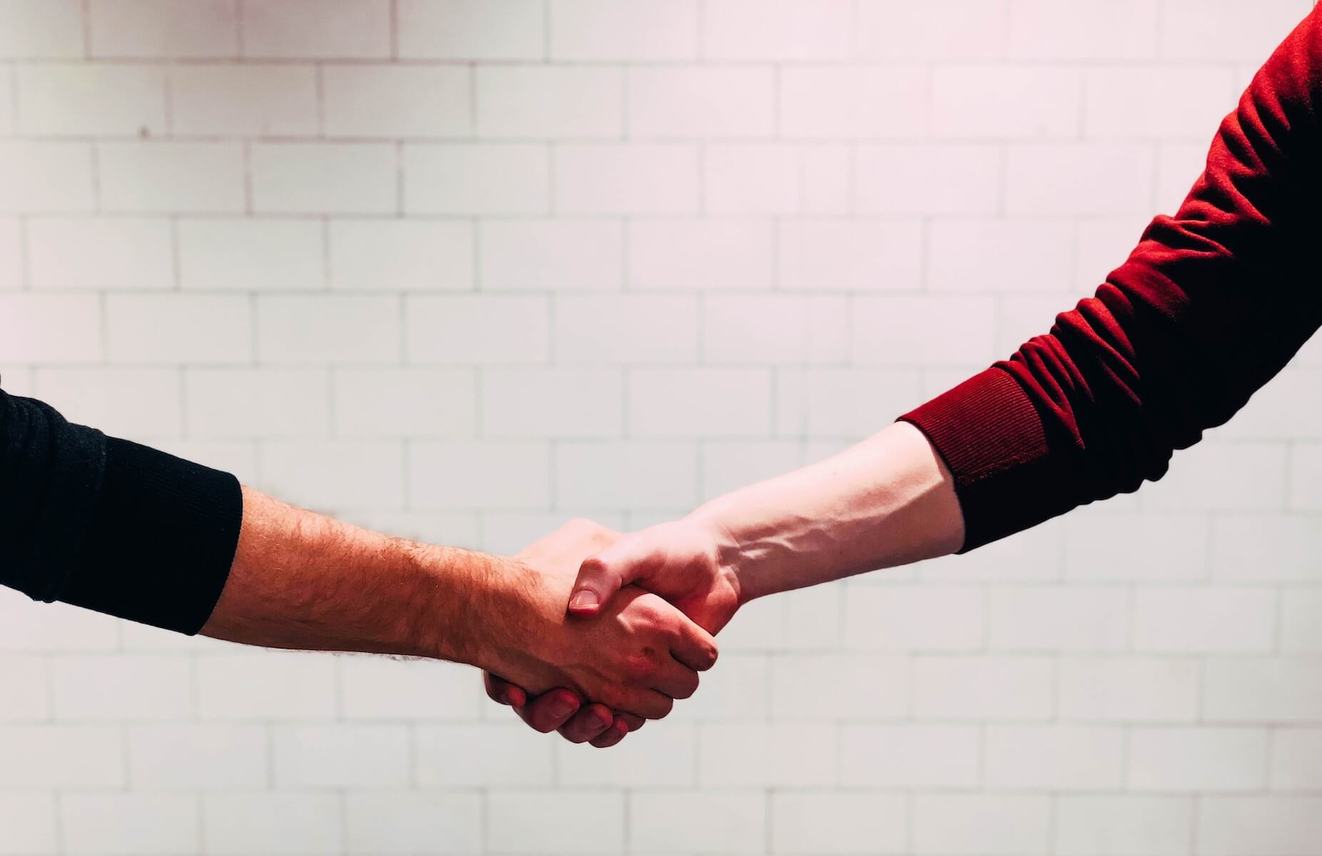 two men shaking hands negotiating travel nurse contract