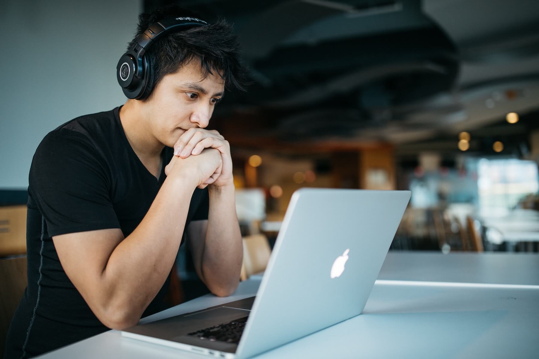 man nurse sitting at cafe with laptop studying for the NCLEX