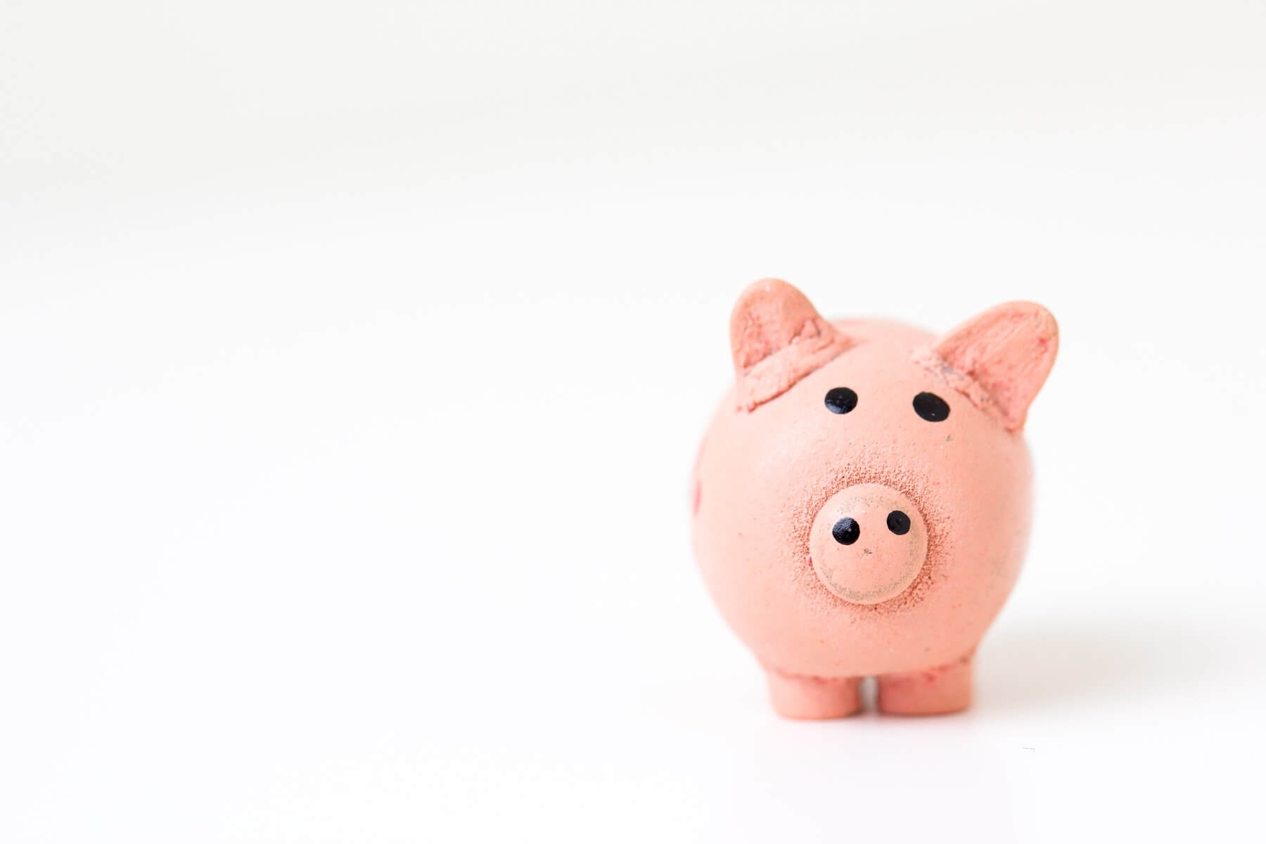 toy pig on white background travel nurse salary compensation pay