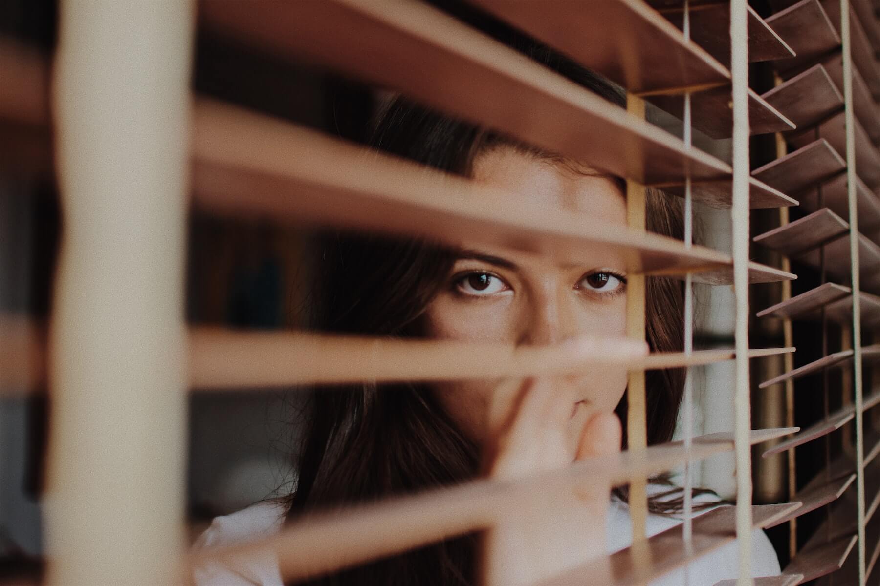 women looking through blinds nurse burnout