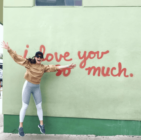 chelsea rofles nurse jumping in front of wall that says i love you so much