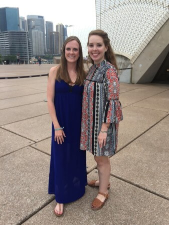 travel nurse duo nurses posing in front of modern building