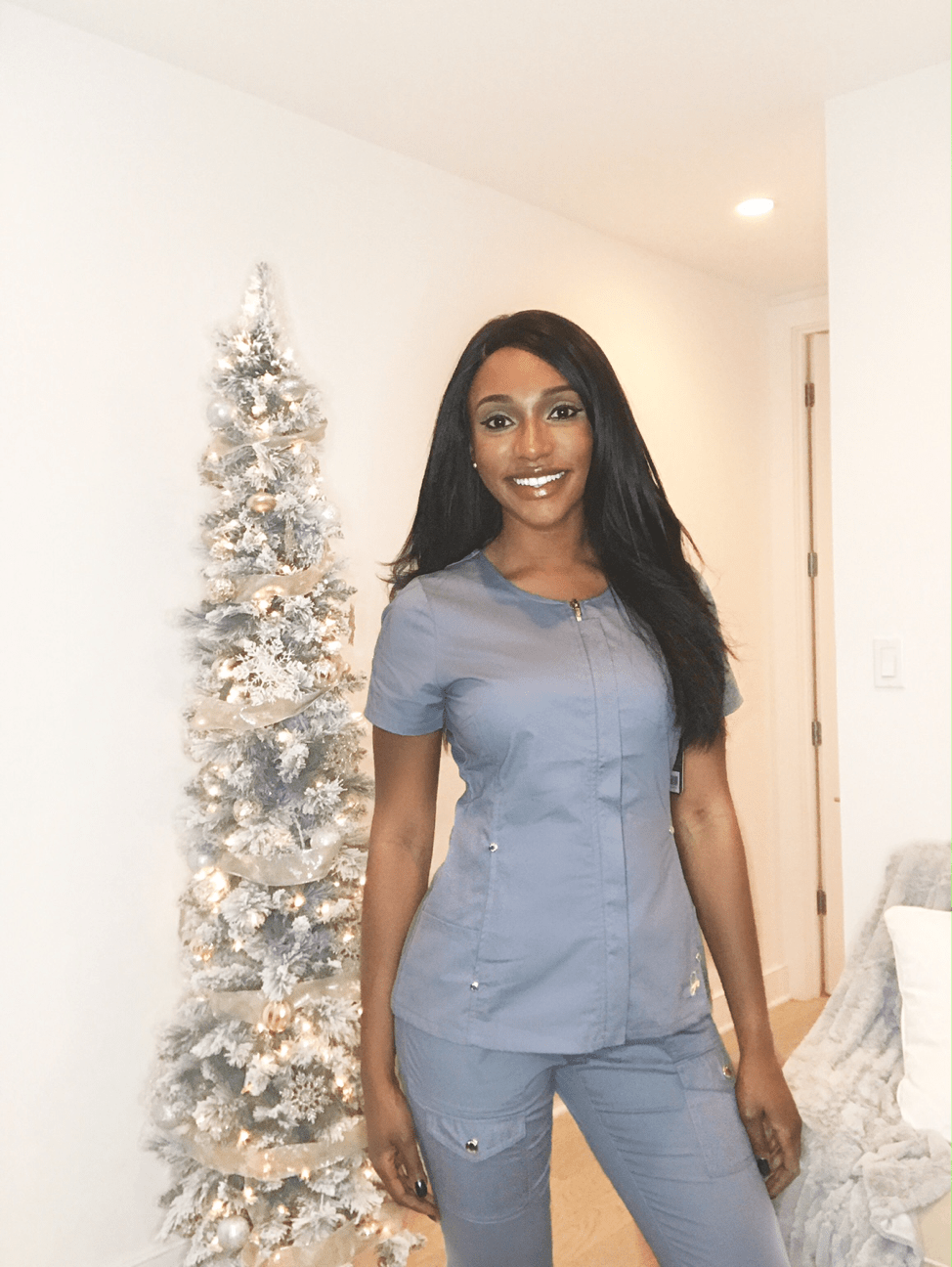 female nurse posing in scrubs in her living room jaanuu scrubs review