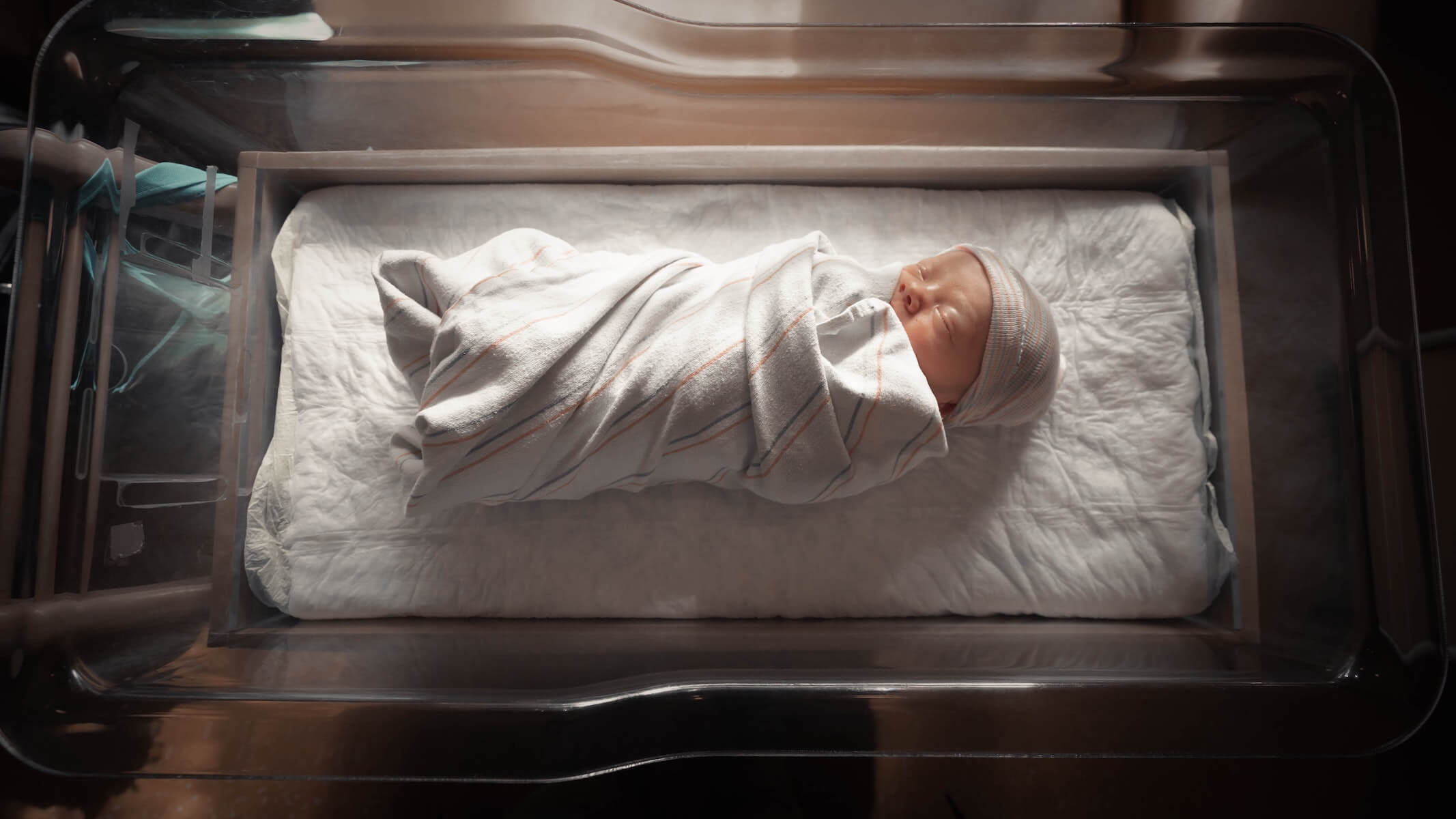 baby sleeping in hospital in open bin neonatal nurse