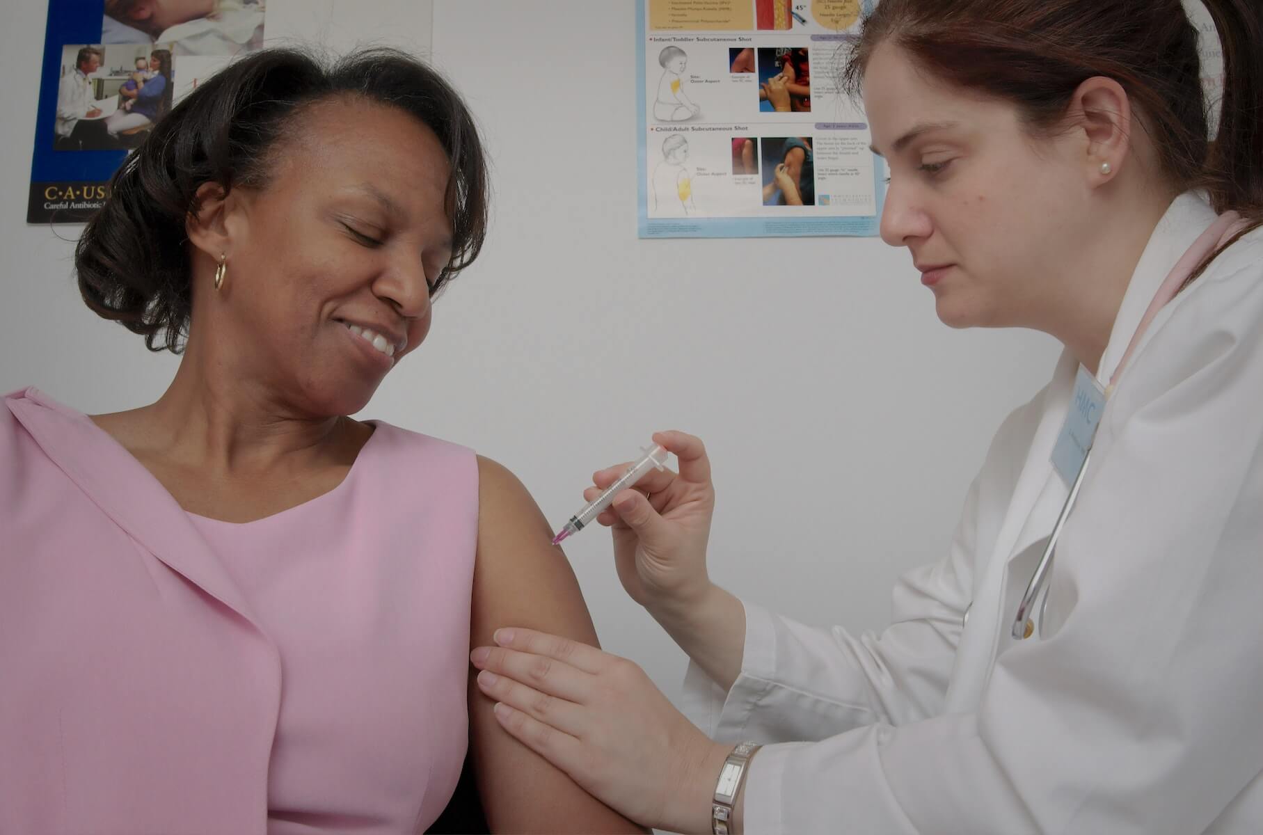 nurse practitioner gives shot to woman FNP