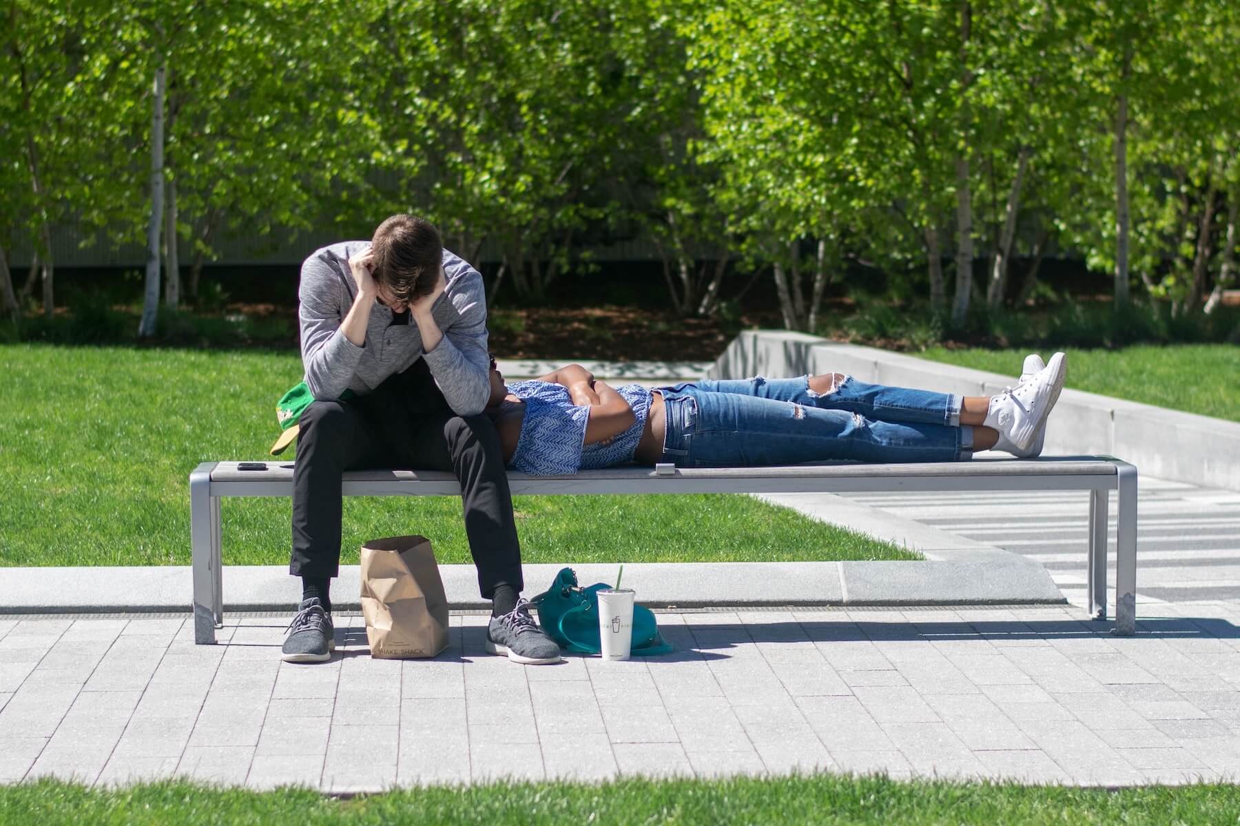 two people siting on bench one laying in the other lap and one with his head down psychiatric nurse practitioner mental health