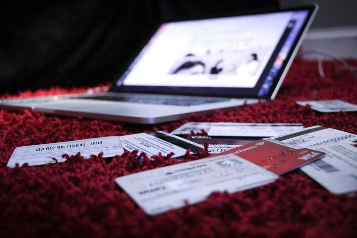 laptop and credit cards on rug nursing debt