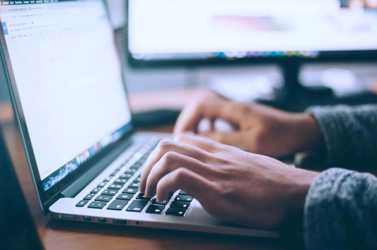 man typing on laptop nursing cover letter