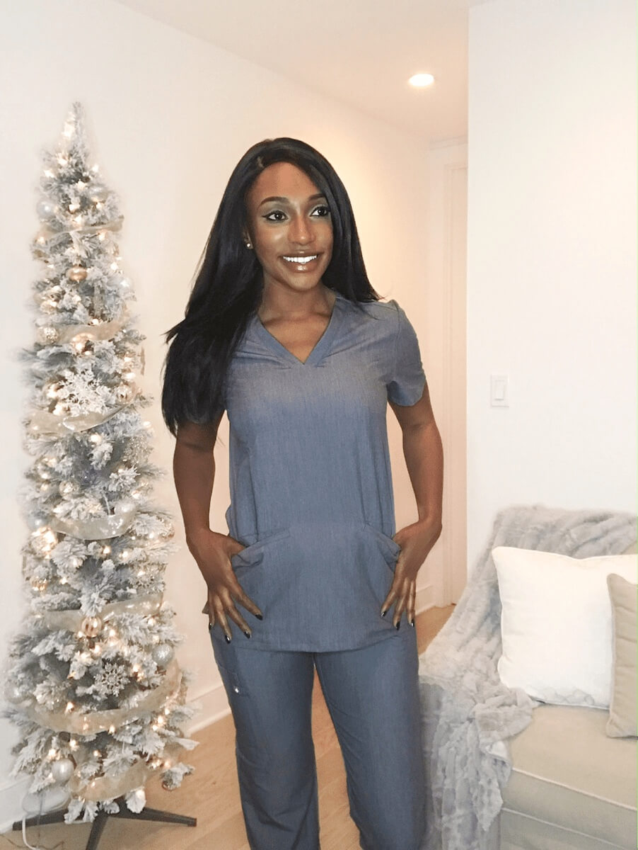 nurse in scrubs posing in living room figs scrubs review