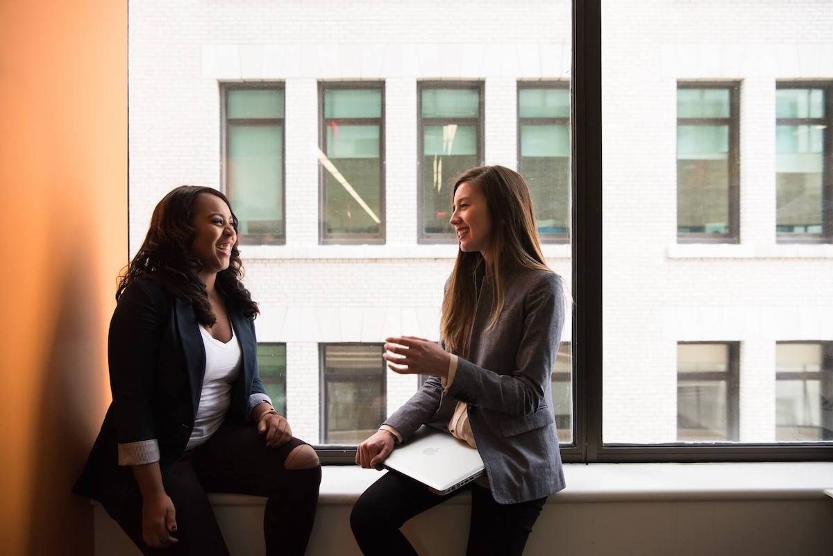 two woman sitting by window talking having conversations allyship in healthcare