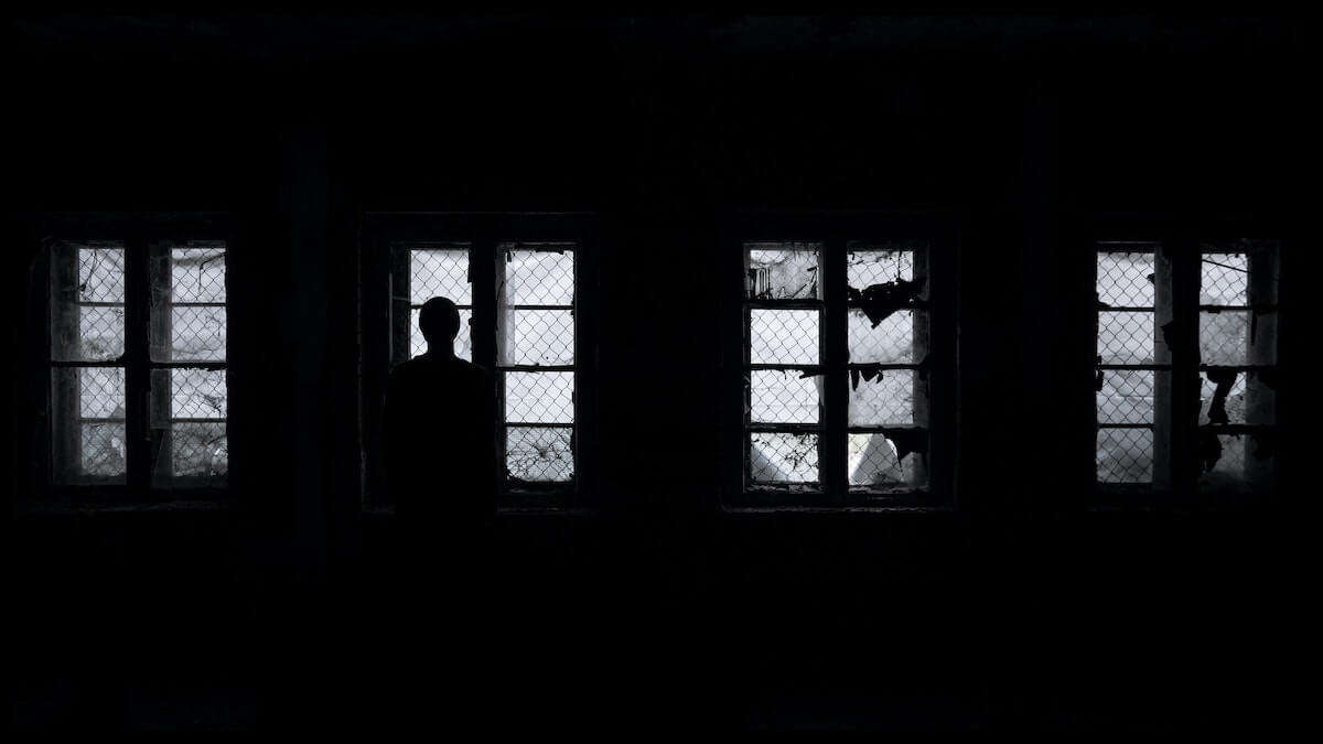 man standing in front of windows in dark room scary nursing stories