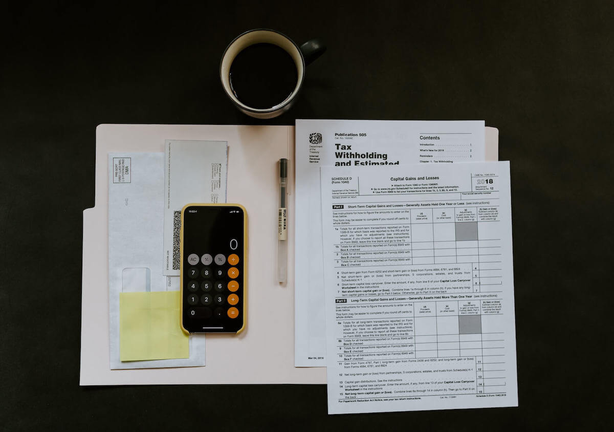tax papers and coffee on black desk travel nurse taxes