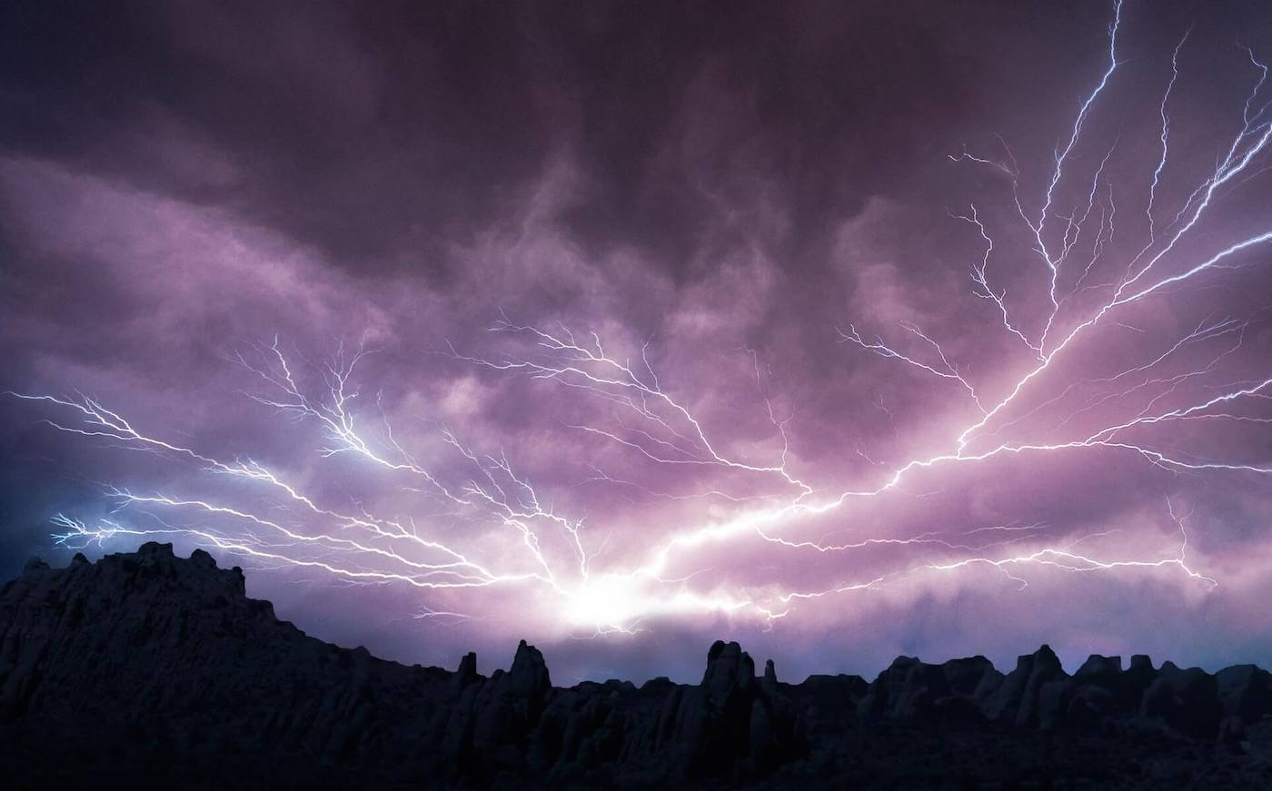 lightning striking in the sky with mountains on the horizon wilderness nursing
