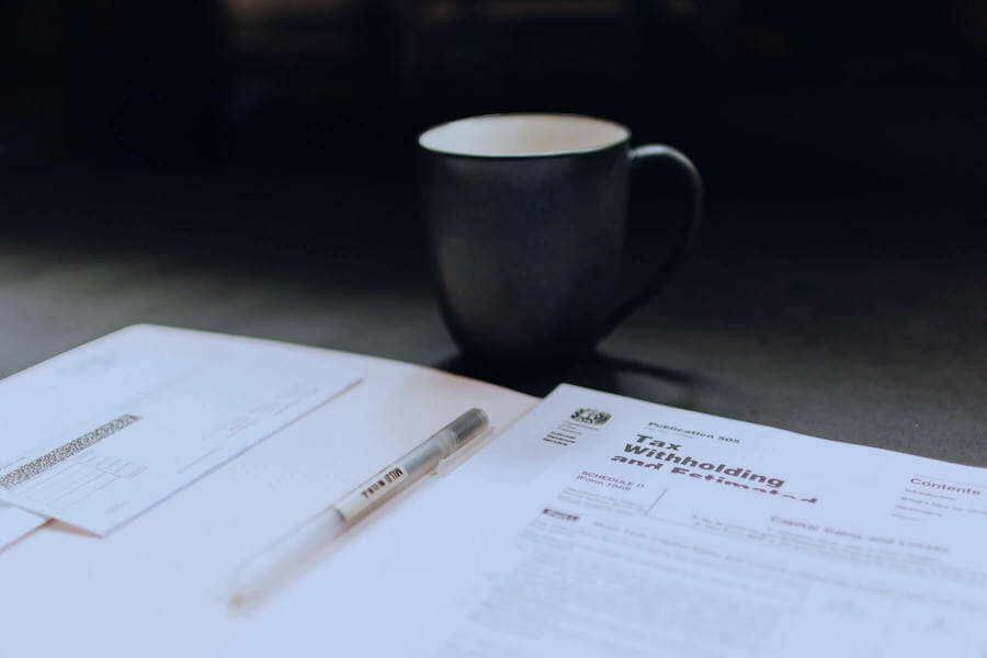 tax paperwork on table next to coffee mug travel nurse taxes
