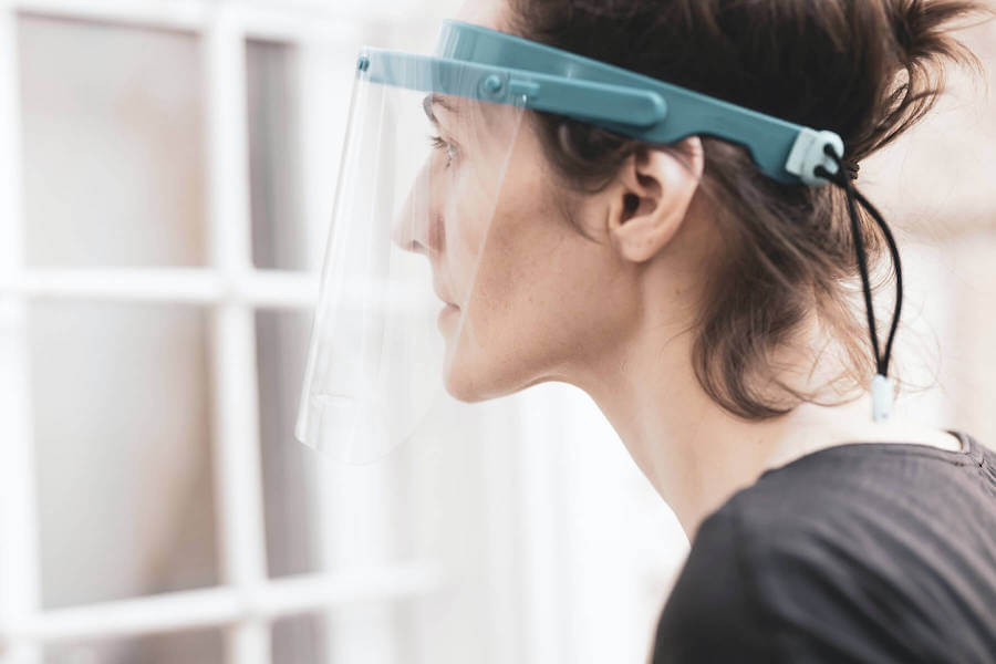 woman thinking with ppe mask on nursing layoffs covid19 furlough nursing jobs