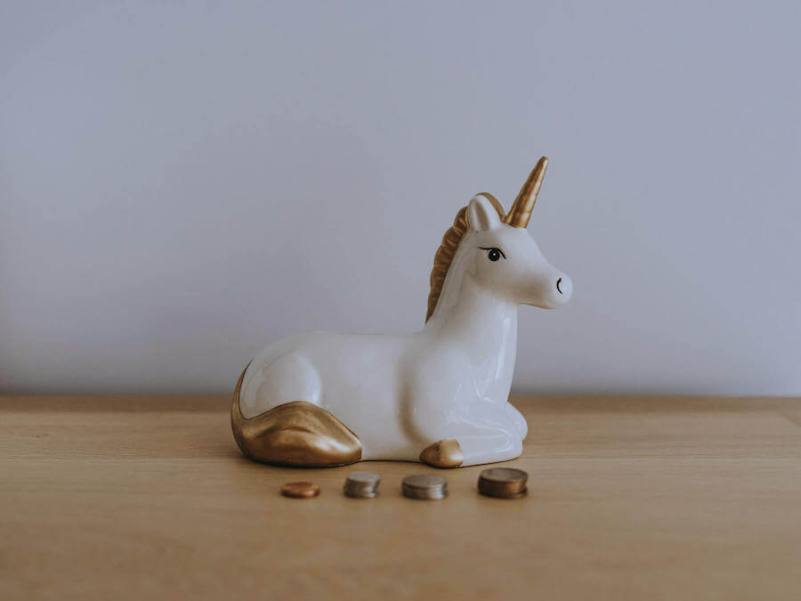 unicorn piggy bank with coin stacked in front of it budgeting for nurses