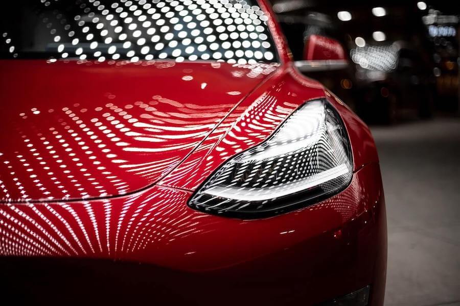 front photo of red tesla right headlight view how nurses can achieve financial freedom