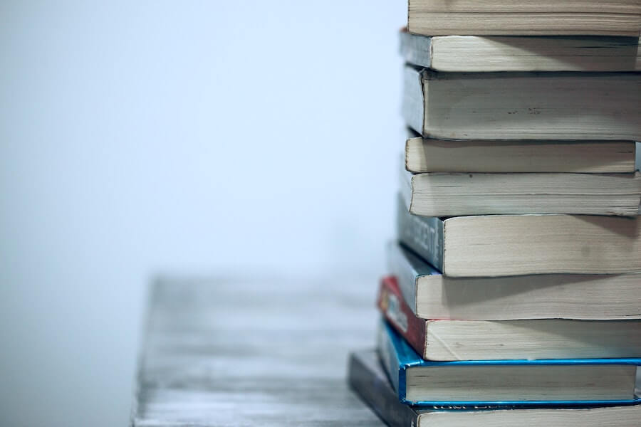 stack of books on wooden table advanced practice nursing education