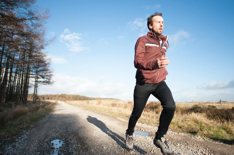 man jogging on country road health insurance for travel nurses