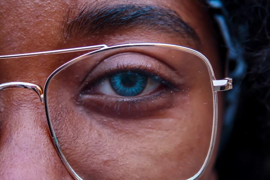 woman looking into camera closeup of her eye blue light glasses
