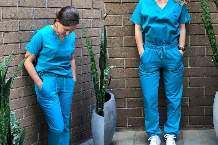 two nurses leaning against a wall modeling nursing scrubs uniform advantage scrubs