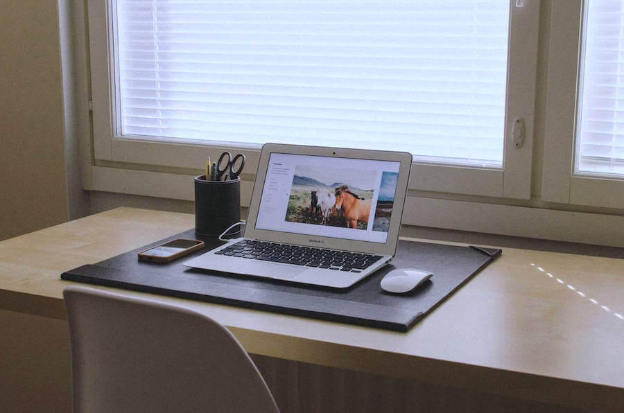 laptop on desk next to office supplies and mouse remote nursing jobs