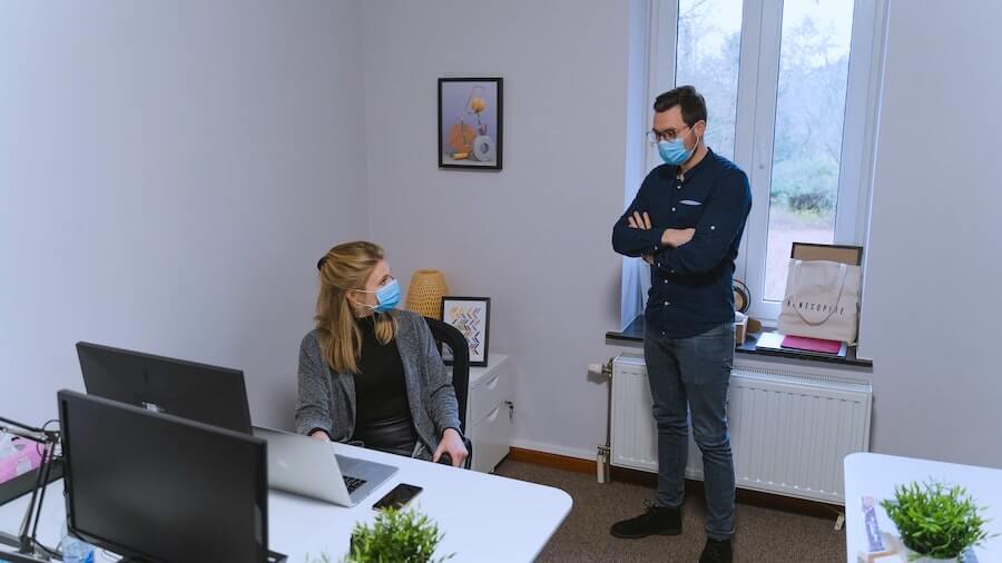 man and woman with masks on in office in front of computer health policy nurse informatics