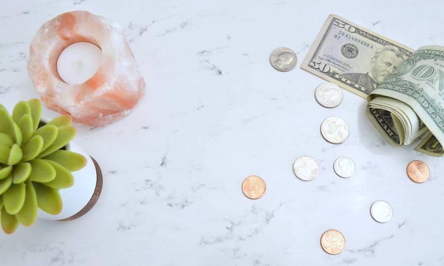 coins money candle and plant on marble desk how much money can you make as a nurse nursing salaries