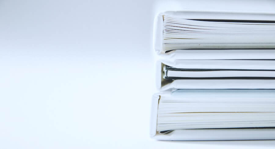 three large paper bindings are table in front of white background how to become an LPN documentation