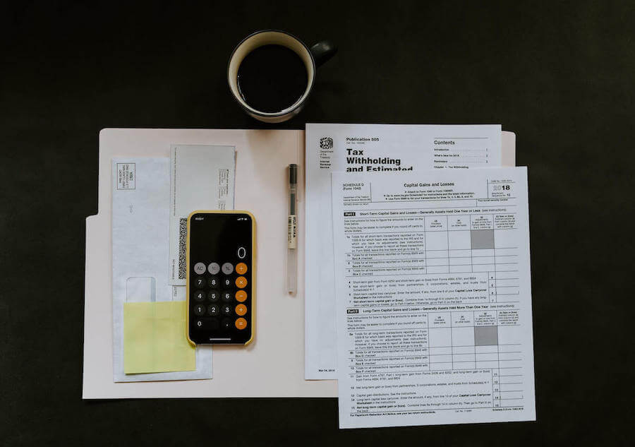 tax papers and coffee on black desk travel nurse taxes