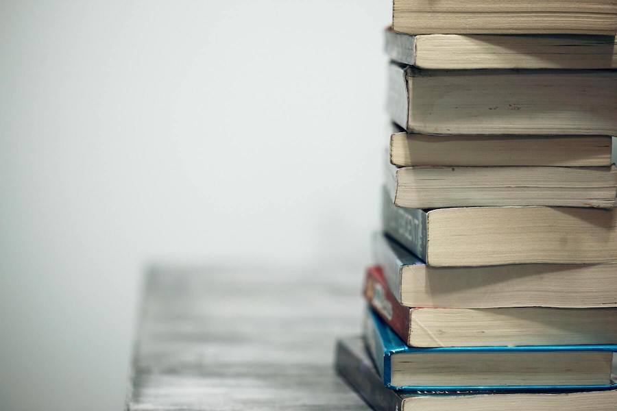 stack of thick text books clinical nurse educator