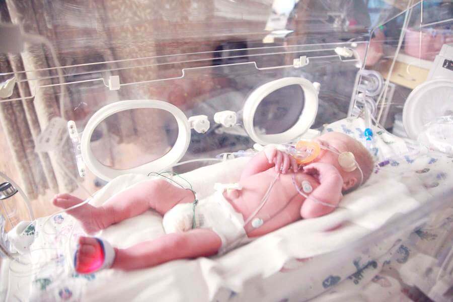 baby in incubator with cables attached neonatal nursing