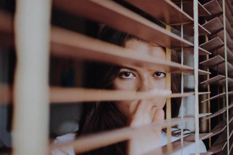 women looking through blinds depressed nurse burnout