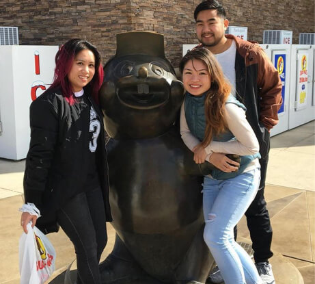 Kaithlyn with some friends by a statue.