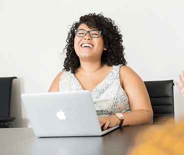 Woman smiling and laughing on computer