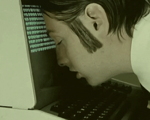 man with his face buried against computer monitor gif