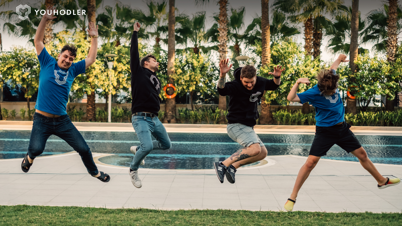the youhodler team jumps in mid-air, arms raised in celebration.