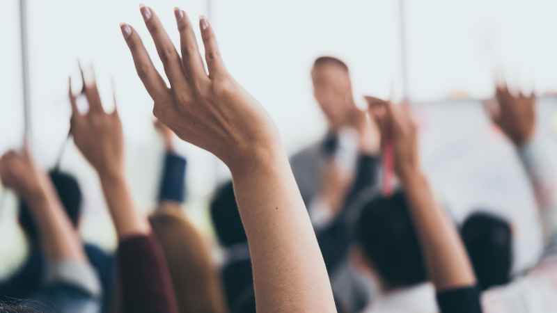 Employees raising their hands during training