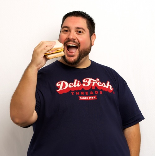 Large man holding a sandwhich to mouth