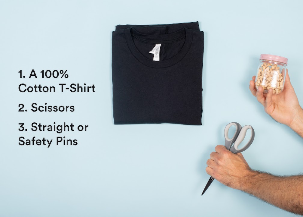 black shirt with man's arms holding scissors and pins