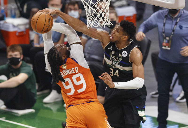 Basketball player blocking other player from scoring