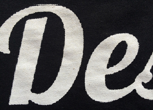 close up of white script graphic on black shirt