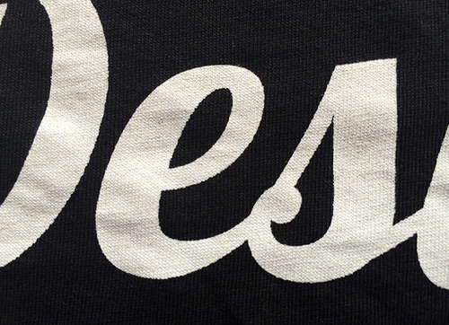 close up of white script graphic on black shirt