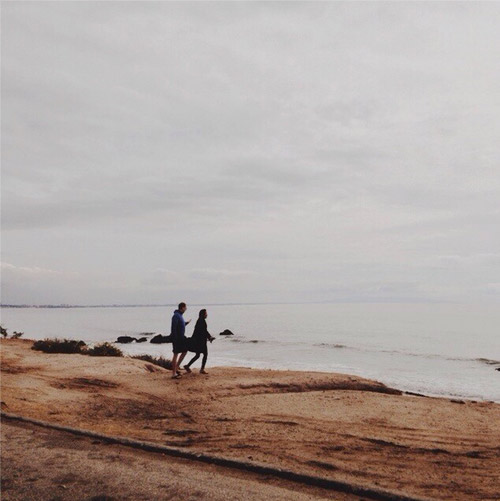 two people walking up to the coastline