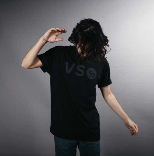 man with long hair modeling a black on black shirt