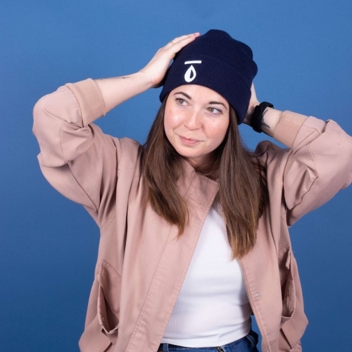 A girl wears a custom embroidered beanie with logo