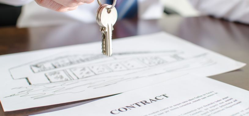 estate agent holding keys over a contract