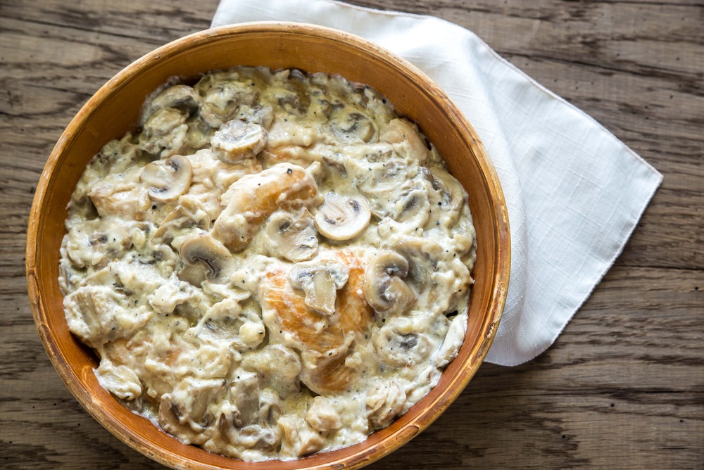 Sur une table rustique et sur un torchon blanc on peut voir, un petit saladier contenant le poulet et