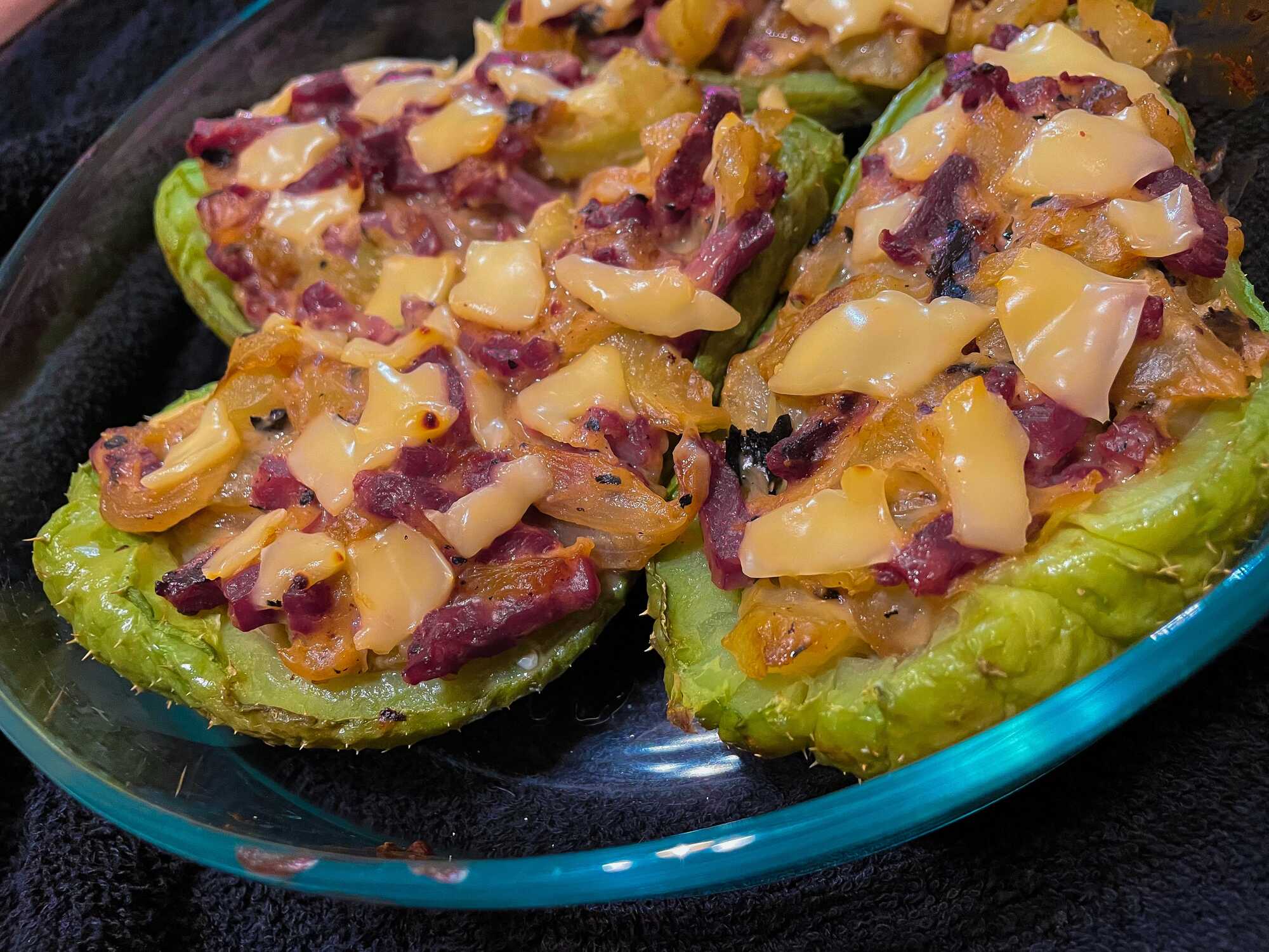 Les christophines sont disposées dans un moule transparent et farcies de lardons, béchamel et fromage fondu.