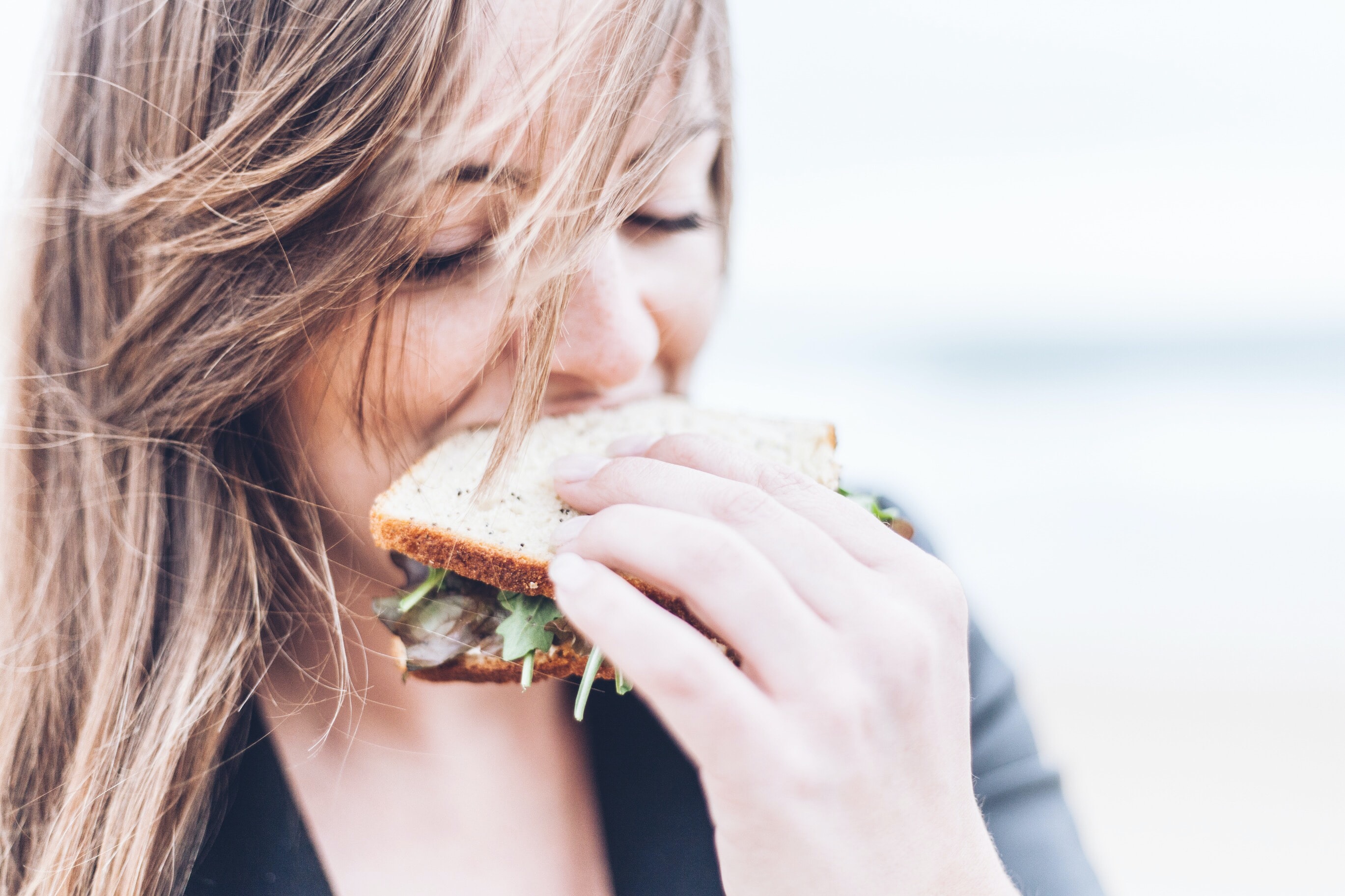 Femme mange un sandwich